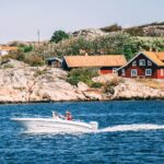 Svenskt fiskeläge med röda sjöbodar vid kusten — Sveriges gömda pärlor