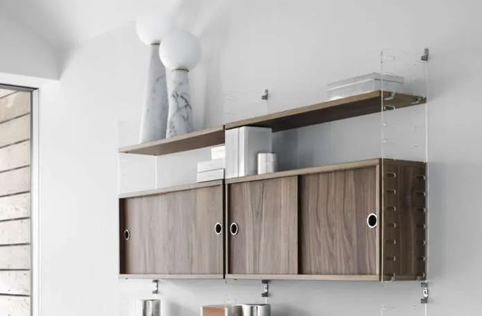 String Plex bokhylla i vardagsrum med valnötsträ